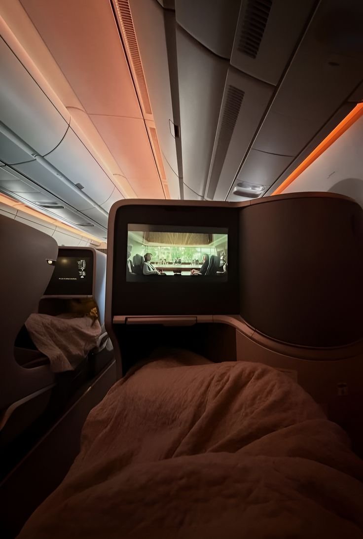 Lie flat bed facing a large entertainment screen